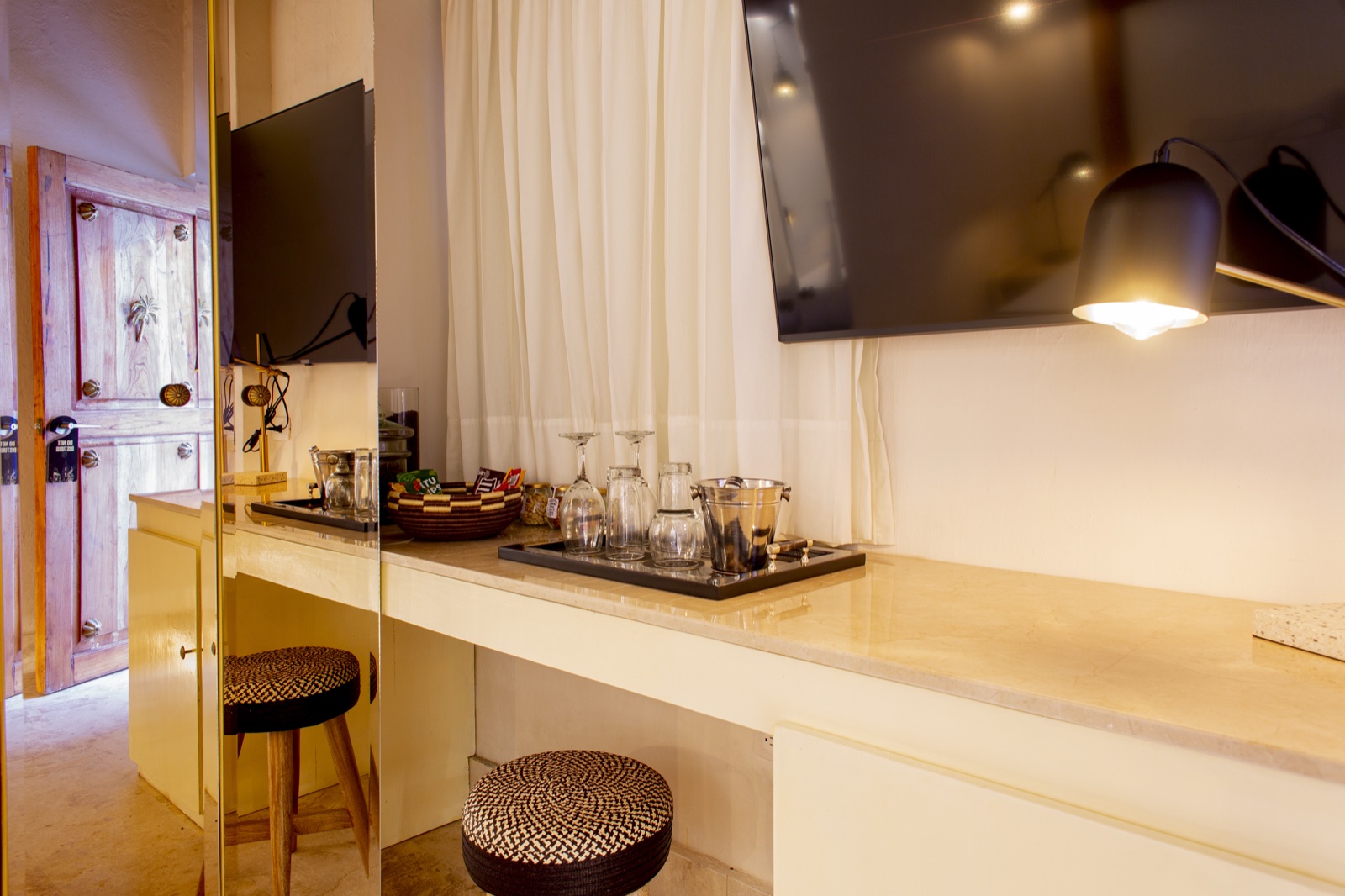 Casa Palmas in-room premium amenities including curated minibar, crystal glassware, flat-screen TV, and artisan welcome tray