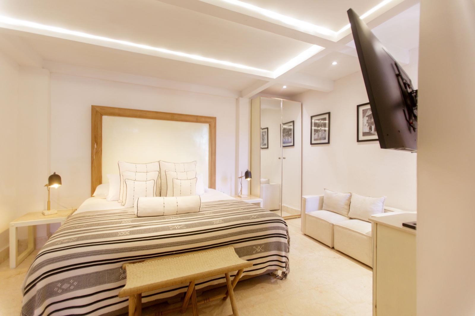 Casa Palmas Junior Suite with custom LED tray ceiling, king bed, built-in sitting area, and walk-in wardrobe mirror